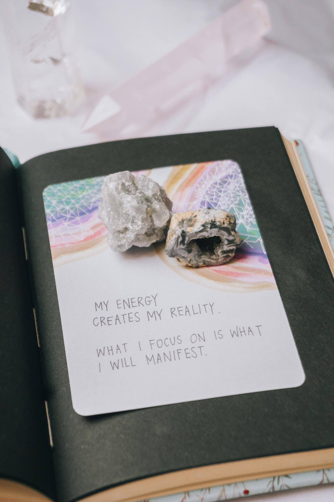 Open journal featuring crystals and an inspiring manifestation quote, perfect for motivation seekers.